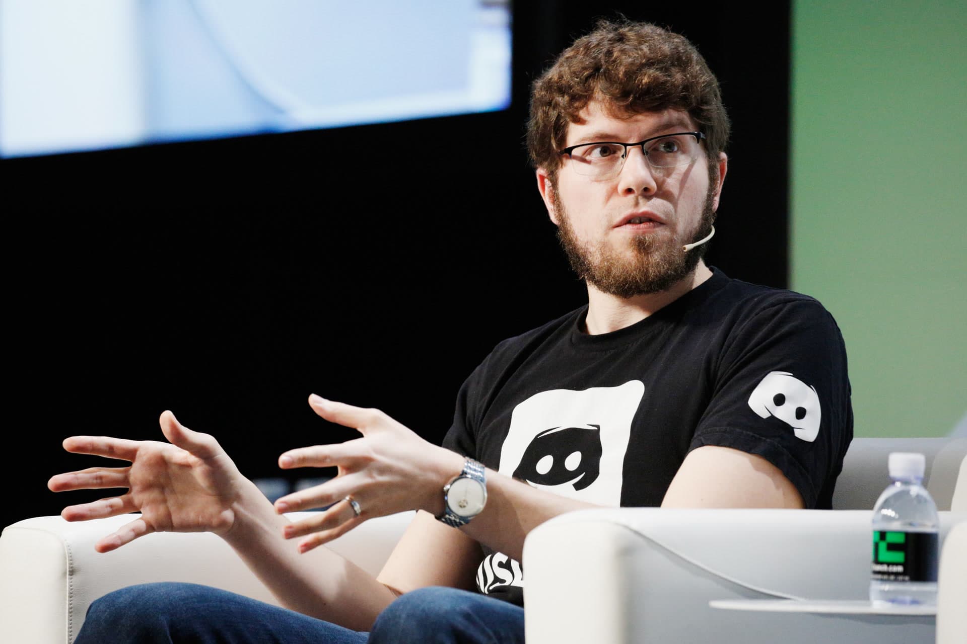 Jason Citron, cofundador do Discord, no palco do TechCrunch Disrupt 2018, de camiseta com o mascote Clyde
