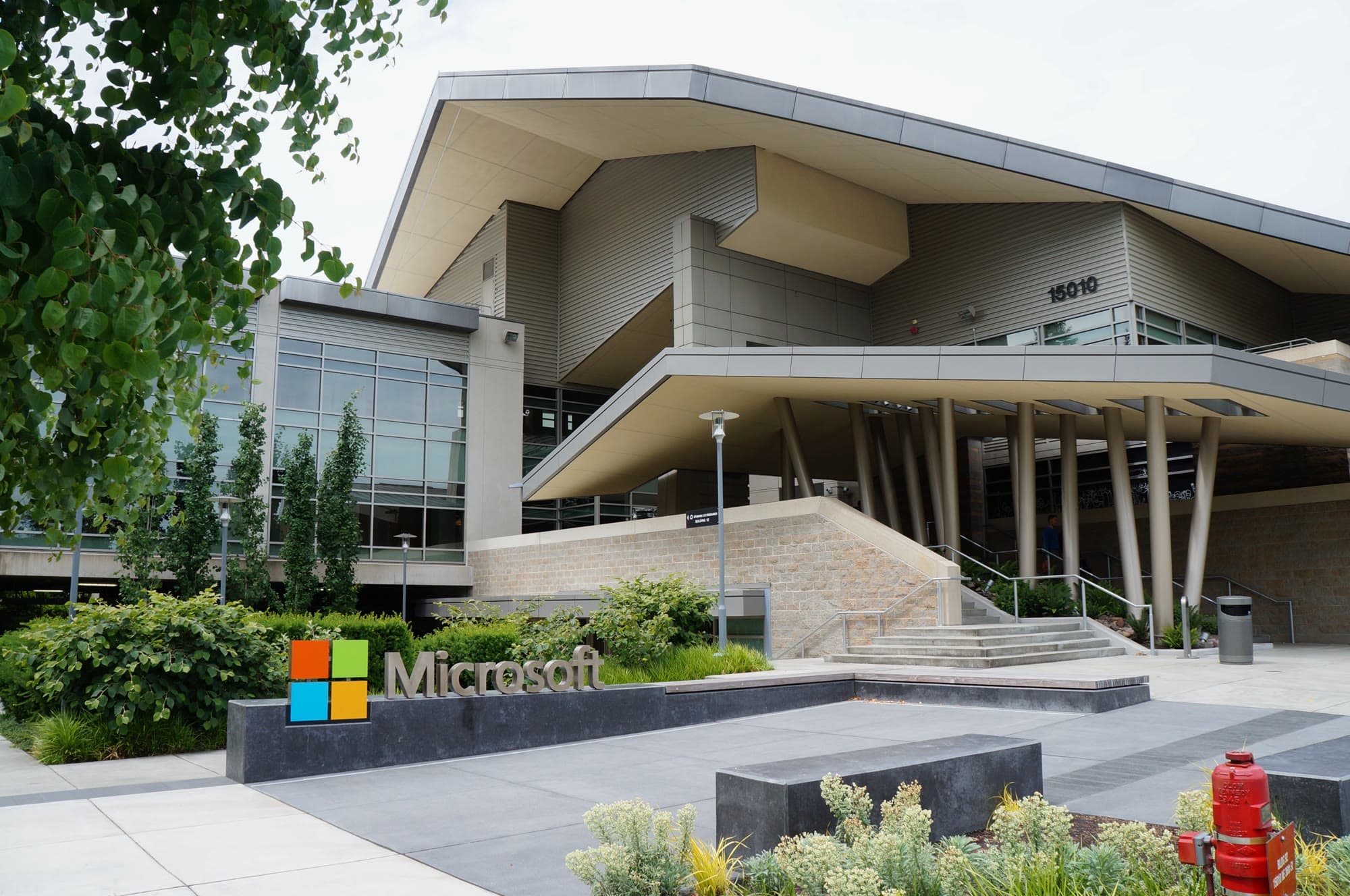 Fachada de vidro do Building 92, centro de visitantes da Microsoft, no campus de Redmond, com o logo da empresa sobre a entrada