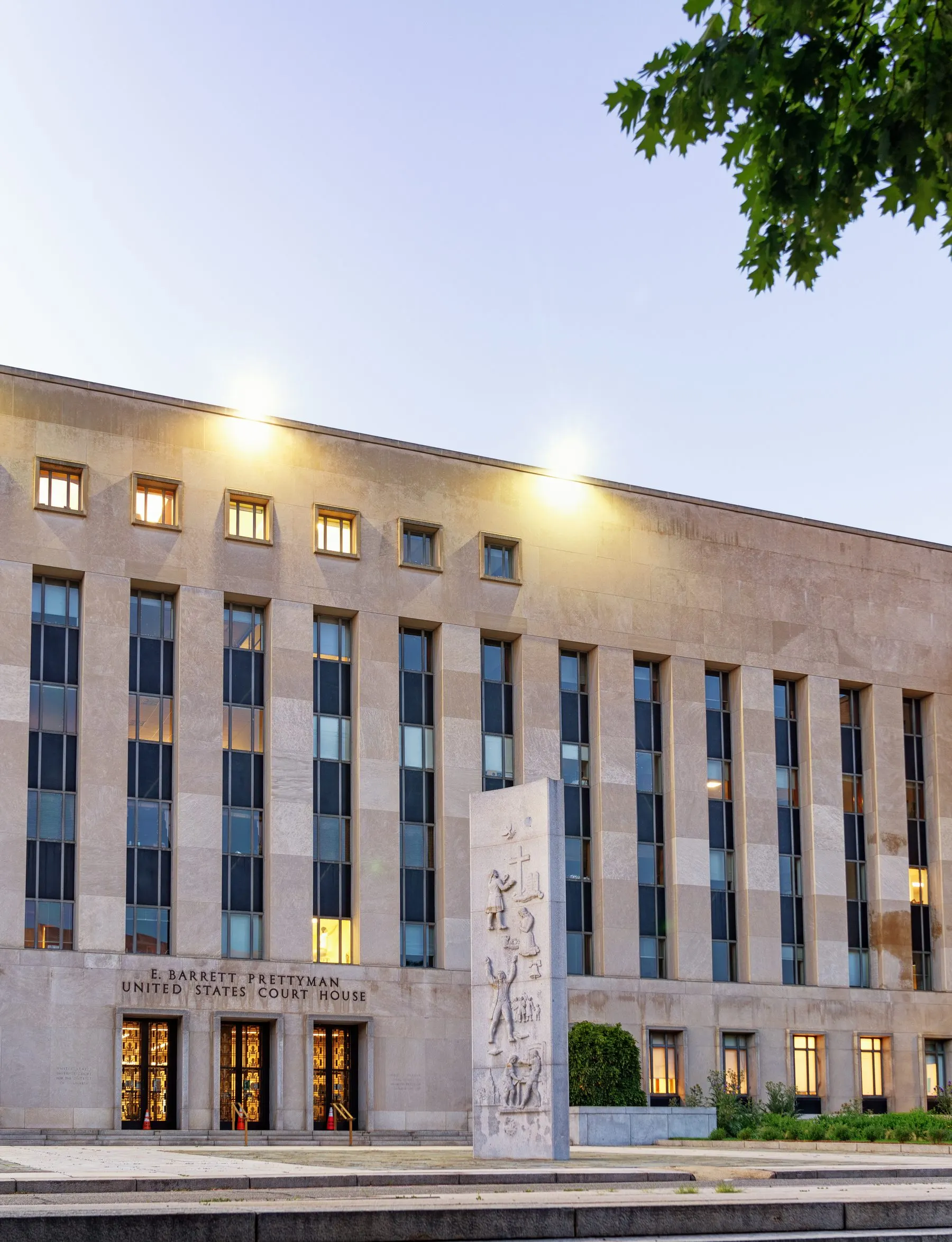 Fachada de pedra clara do tribunal E. Barrett Prettyman, em Washington, com colunas, bandeiras dos Estados Unidos e o nome do prédio acima da entrada
