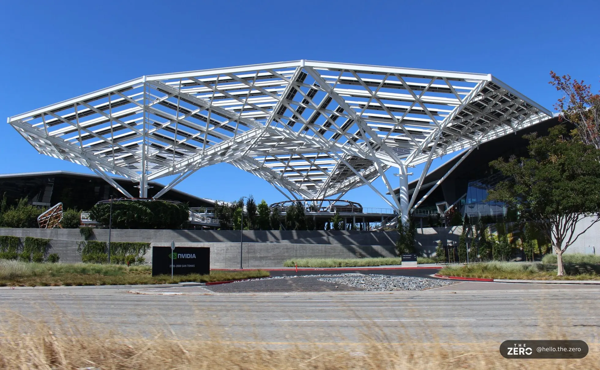 Entrada da sede da Nvidia em Santa Clara, com fachada de vidro e painéis claros e o logotipo NVIDIA em preto acima das portas