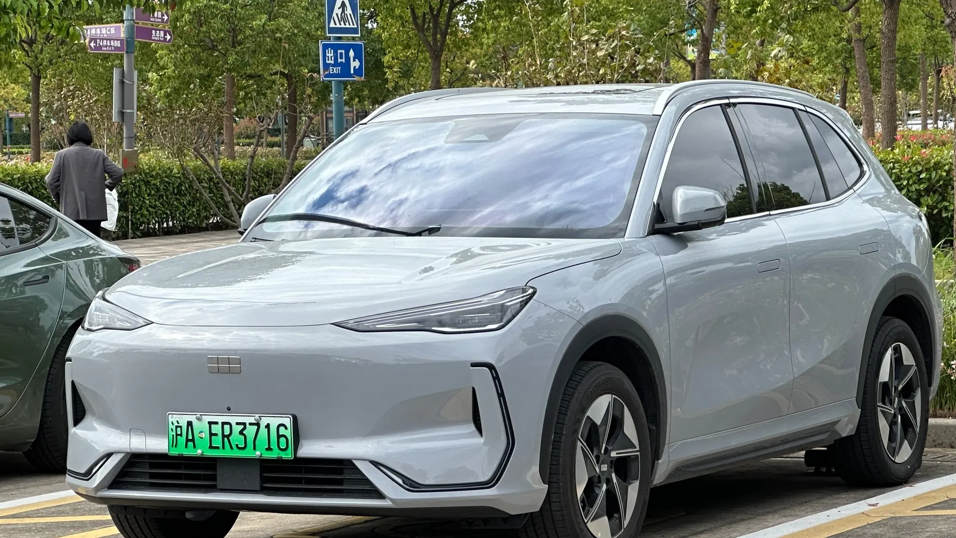SUV elétrico Geely Galaxy E5 prata, vendido no Brasil como EX5, estacionado em rua arborizada na China