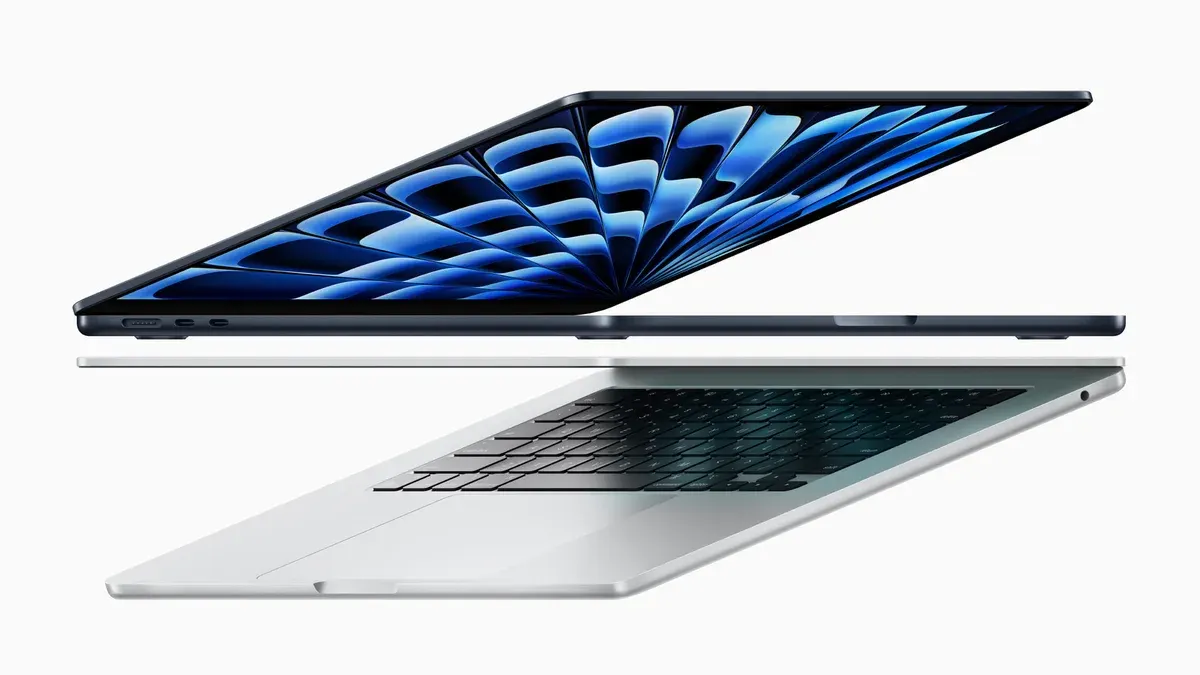Dois MacBook Air M3 abertos, um meia-noite em cima e um prateado embaixo, vistos de lado.