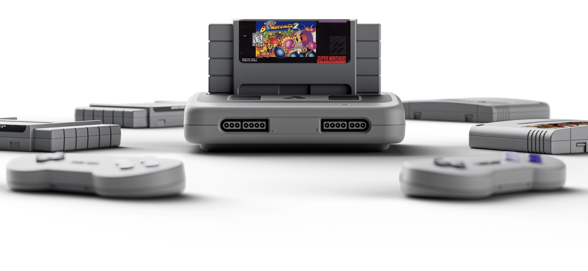 Console Analogue Super Nt cinza claro com cartucho de Super Bomberman 2 inserido no topo, ladeado por cartuchos e dois controles sem fio desfocados à frente sobre fundo branco