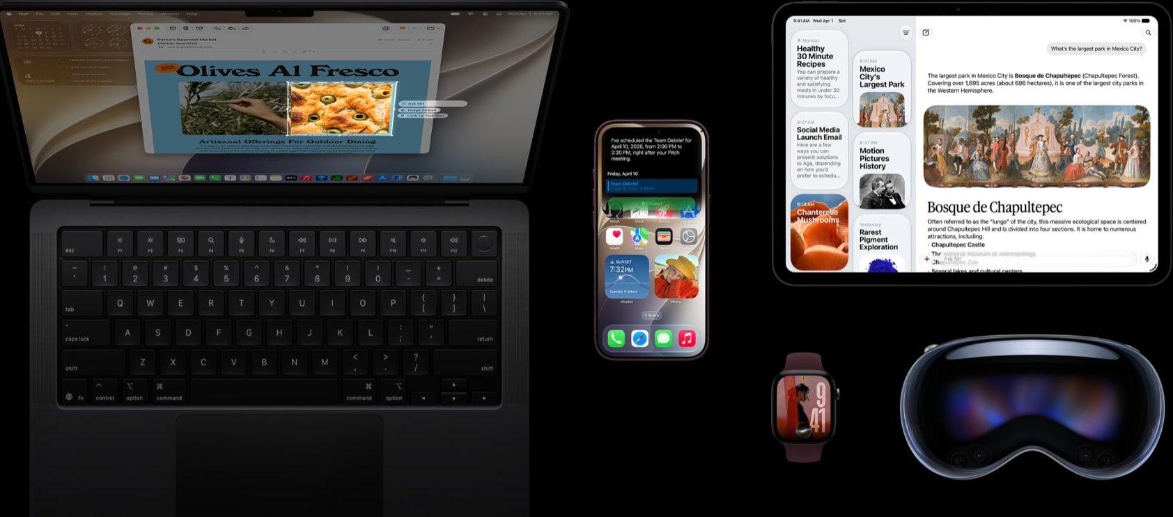 MacBook aberto com a tela ligada ao lado de iPhone, iPad, Apple Watch e headset Apple Vision Pro sobre fundo preto