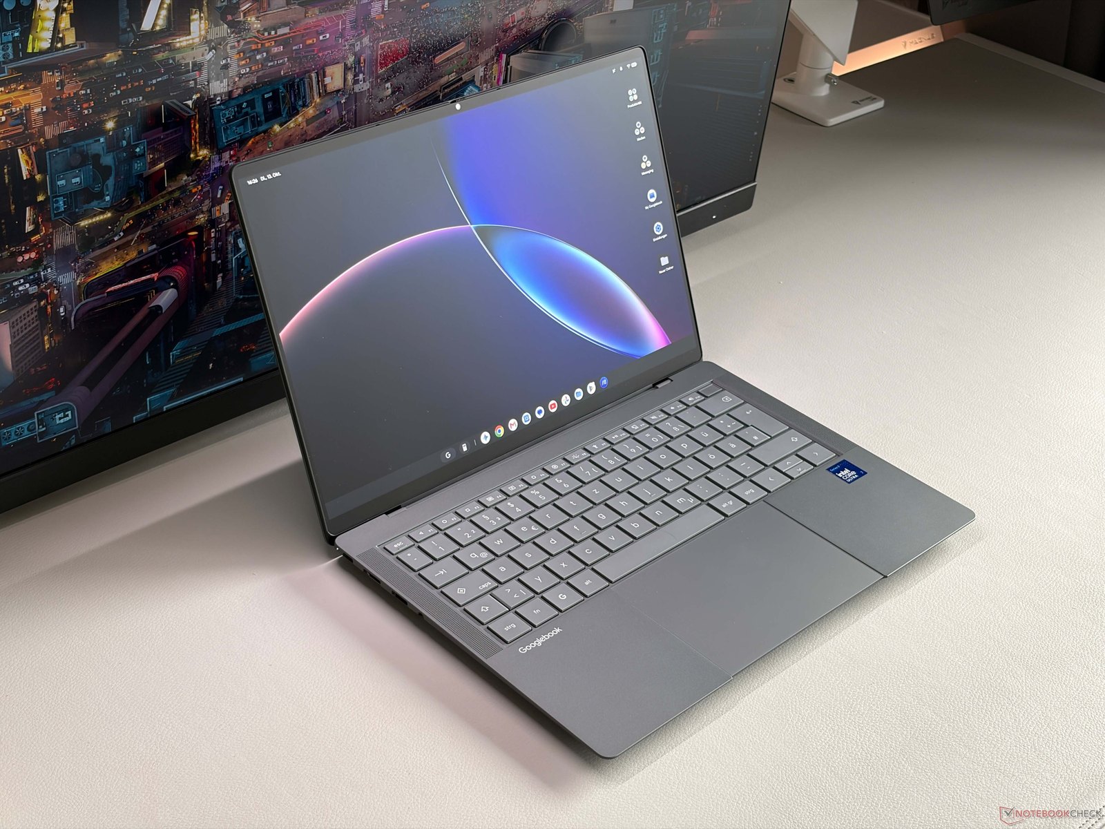 Notebook Asus Googlebook 14 cinza aberto sobre uma mesa, com a tela ligada e o teclado à mostra.